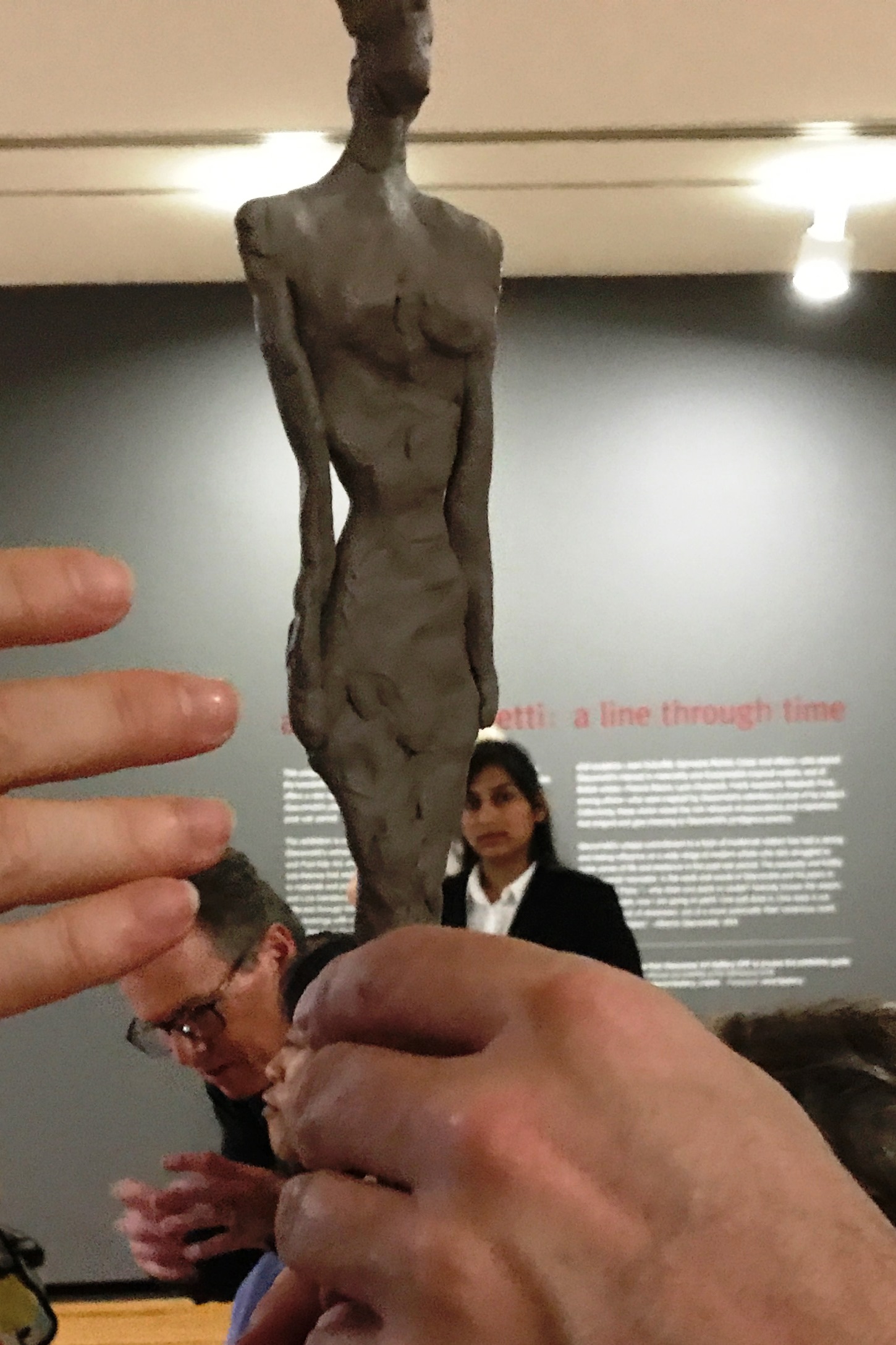 Shawn holds a clay replica of a GIACOMETTI sculpture 