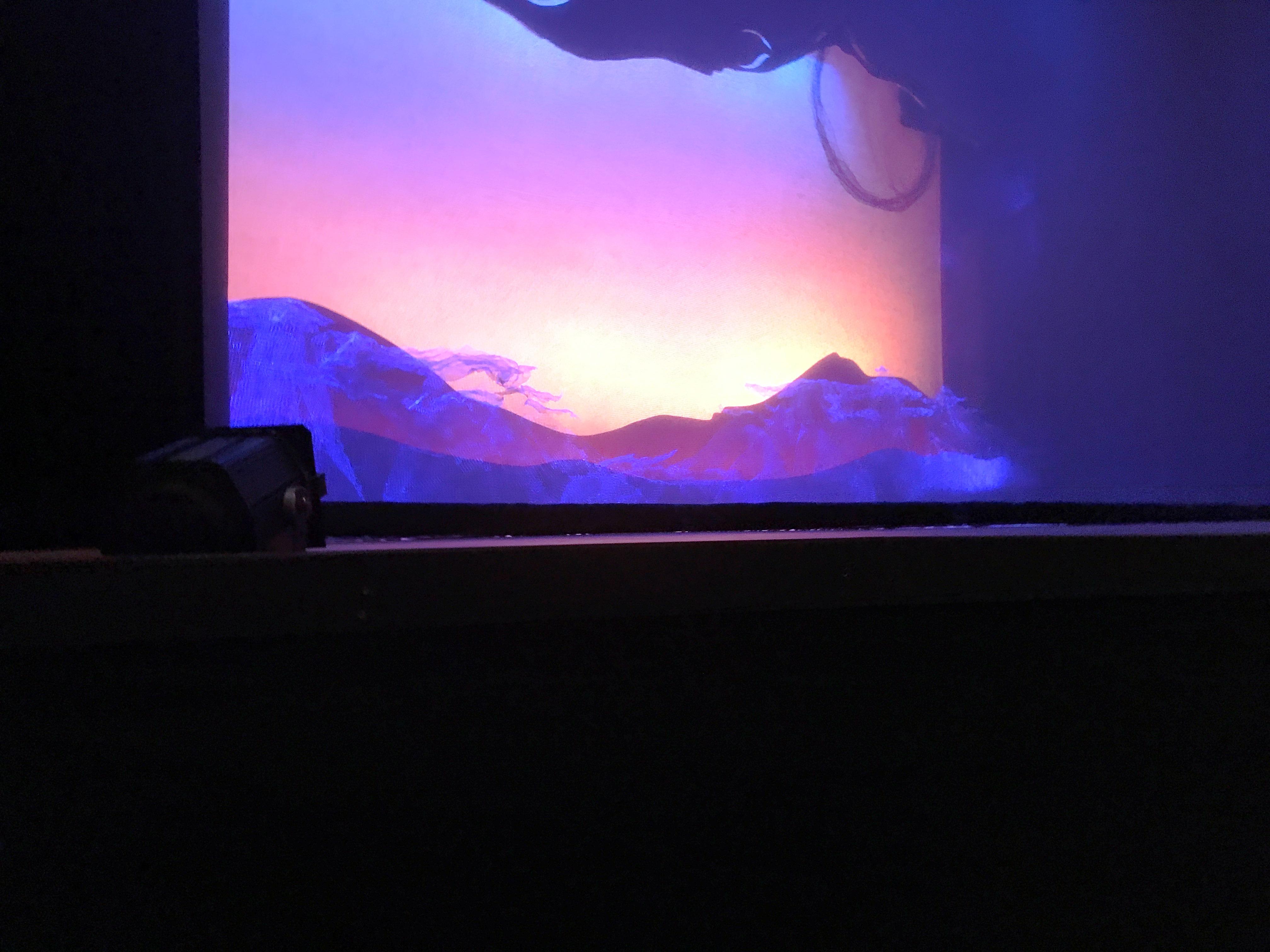 Stage during intermission - A silhouette of mountains against a sunset sky